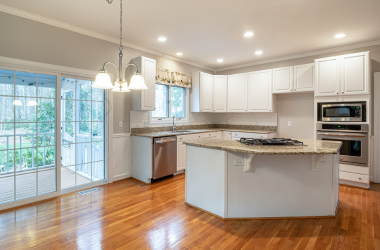 Home Modern kitchen remodel with white cabinets, granite countertops, hardwood floors, and large center island sliding door