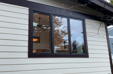 Home Modern black frame window installation on house exterior with hardie siding